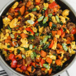 breakfast sausage and sweet potato egg scramble in black pan