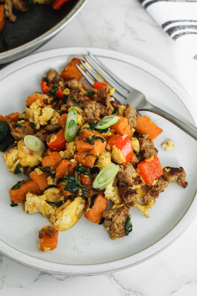 Sausage and sweet potato scramble breakfast in white plate