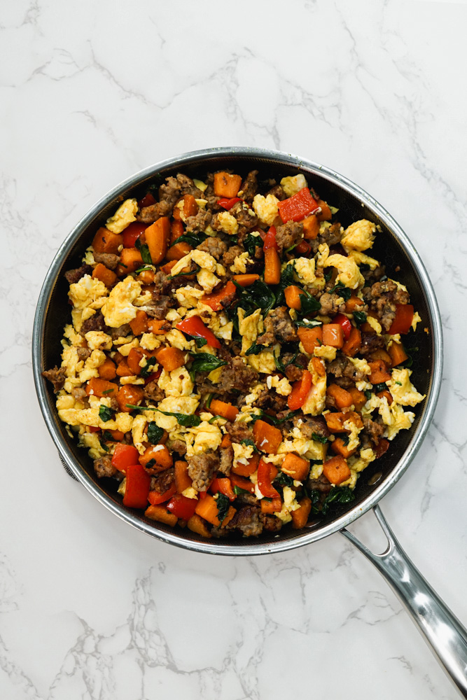 black pan with sausage, sweet potato, red bell pepper, spinach and egg