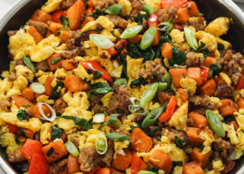 breakfast sausage and sweet potato egg scramble in black pan