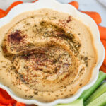 Homemade hummus in white bowl with veggies