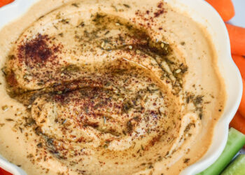 Homemade hummus in white bowl with veggies