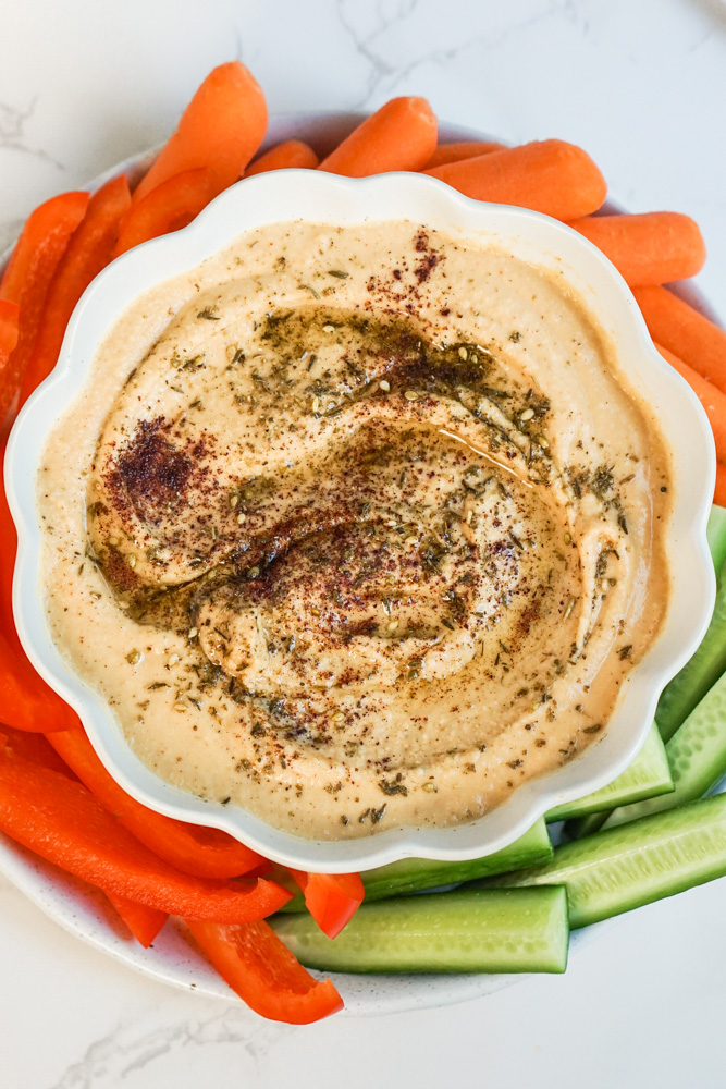 Homemade Hummus on white plate with vegetables