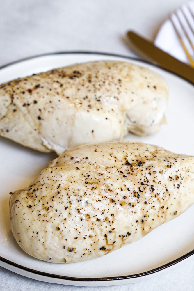 Two cooked chicken breast on white plate 