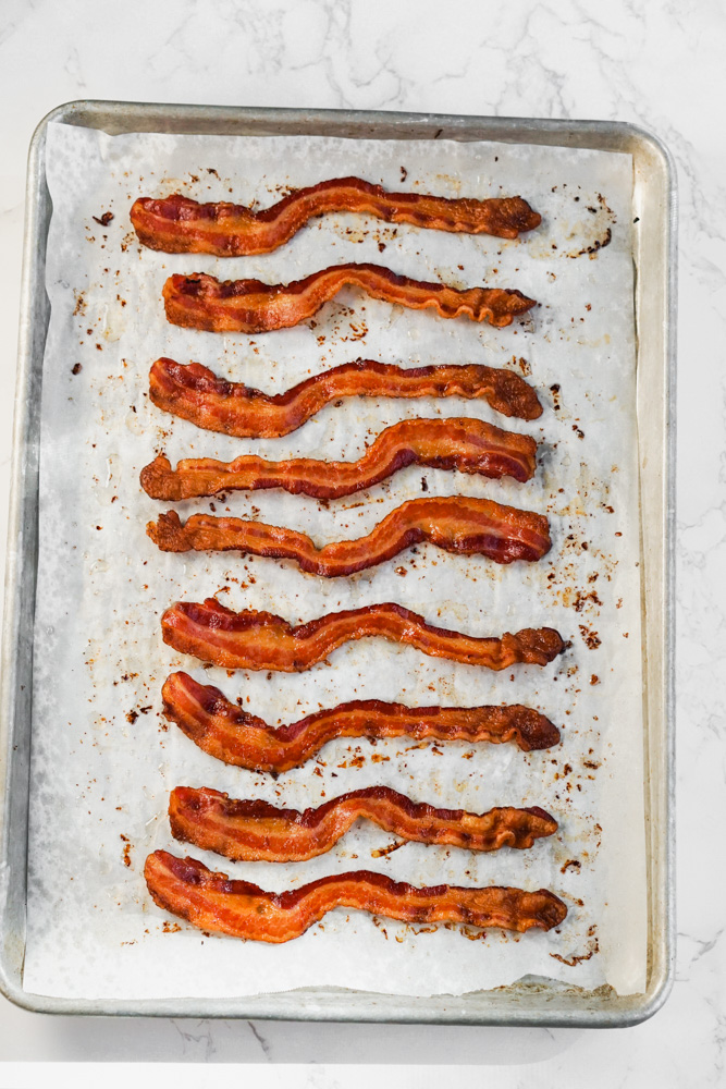 Cooked crispy oven baked bacon on baking sheet